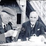 Due signori fanno colazione seduti davanti ad una baita di montagna, Anni '20