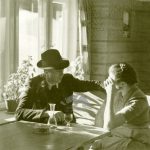 Una coppia chiacchiera all'interno di un locale a Selva di Val Gardena, 1950-1960