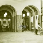 La Galleria dell'OIR a Cesena tra il 1950 e il 1960. In primo piano un cameriere sistema sedie e tavolini del Bar Roma. Sullo sfondo il vecchio palazzo della TIMO