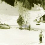 Paesaggio innevato di montagna con baite e sciatore negli Anni '50
