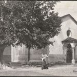 Aosta, una donna trasporta una gerla davanto alla chiesa di S. Orso