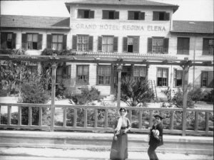 Una giovane donna e un ragazzino sorridenti davanti al Grand Hotel Regina Elena di Palermo nel 1914
