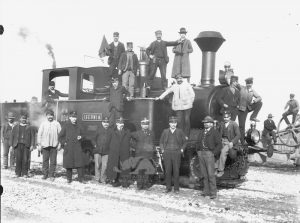 Tutti in posa, ferrovieri, macchinisti, passeggeri intorno a una delle prime locomotive in servizio sulla linea Bologna-Rimini-Ancona, negli Anni '10