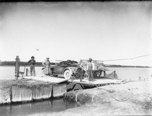 Un auto e un carro e tre persone traghettano sul Po di Mesola, 1929